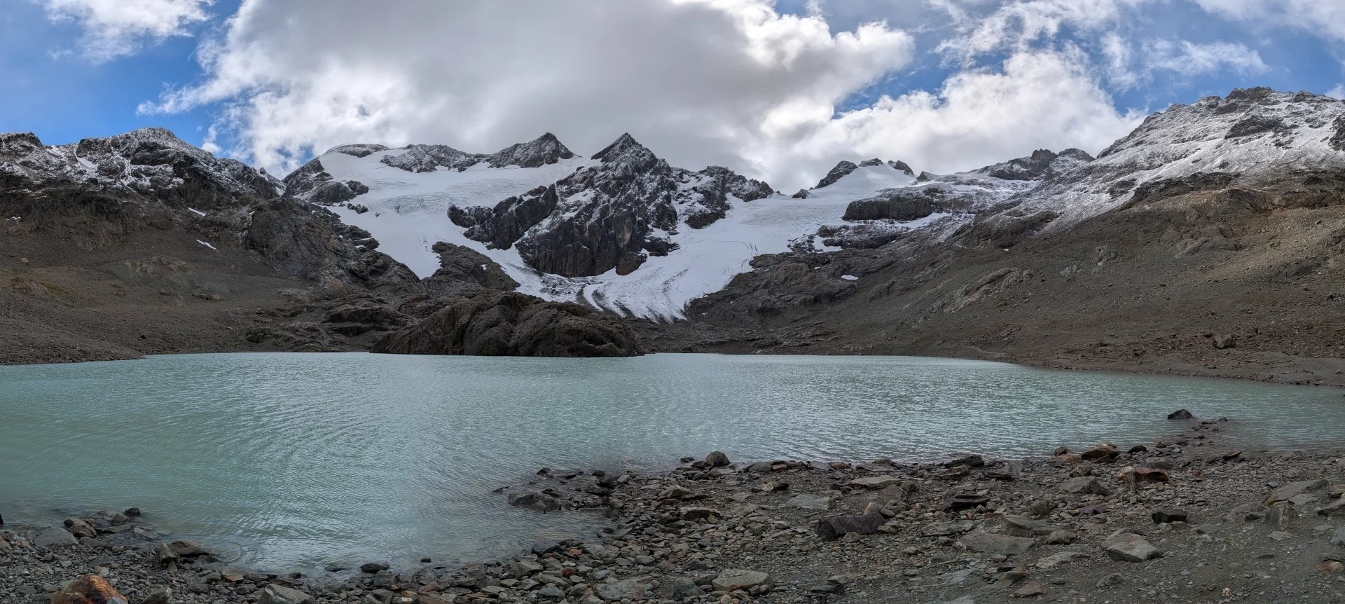 Panoràmica del llac i el glacial Vinciguerra sobre les muntanyes.