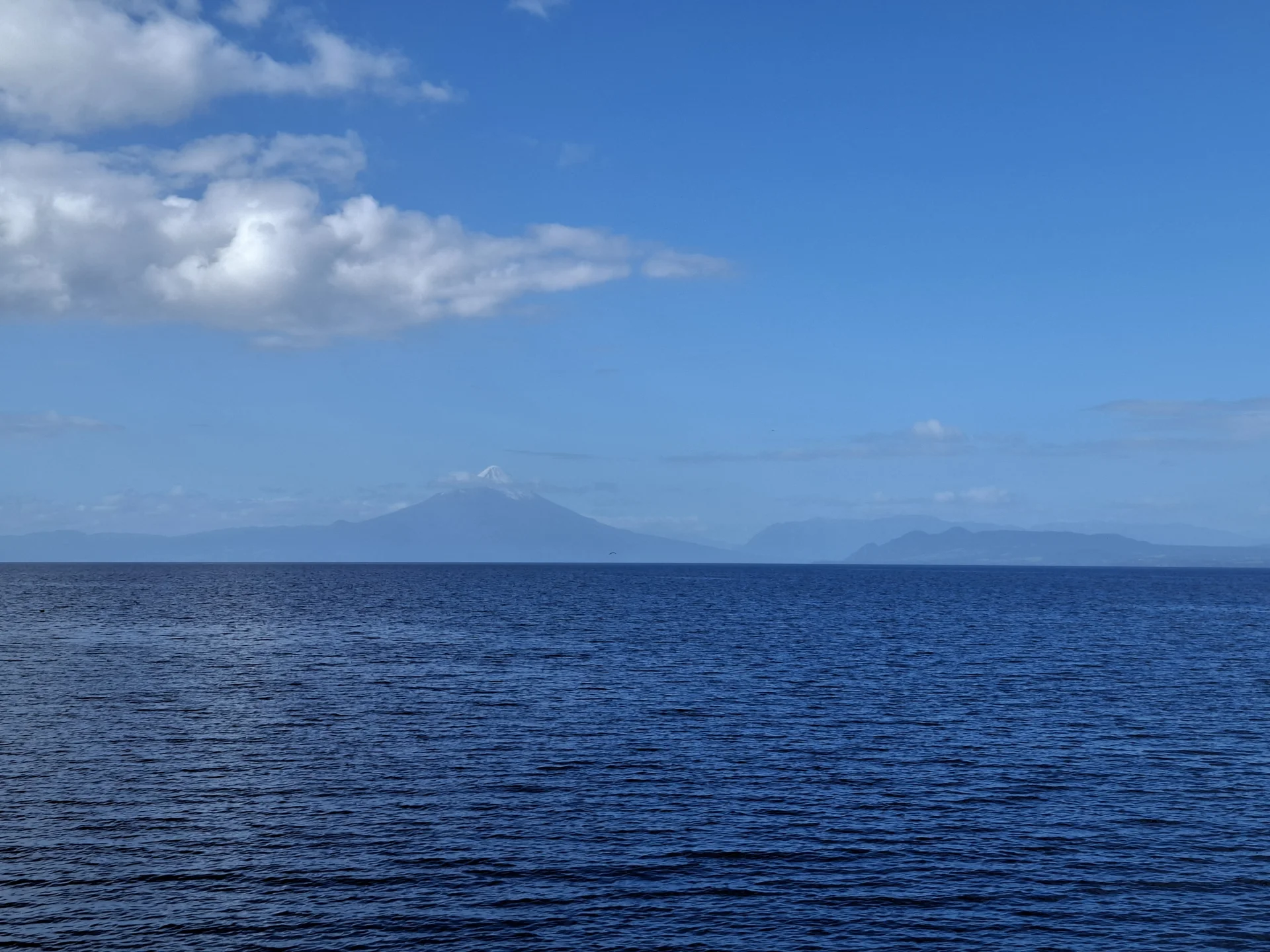En la imatge s’hi observa el llac Llanquihue i al fons, una mica desdibuixat, es pot veure el volcà Osorno.