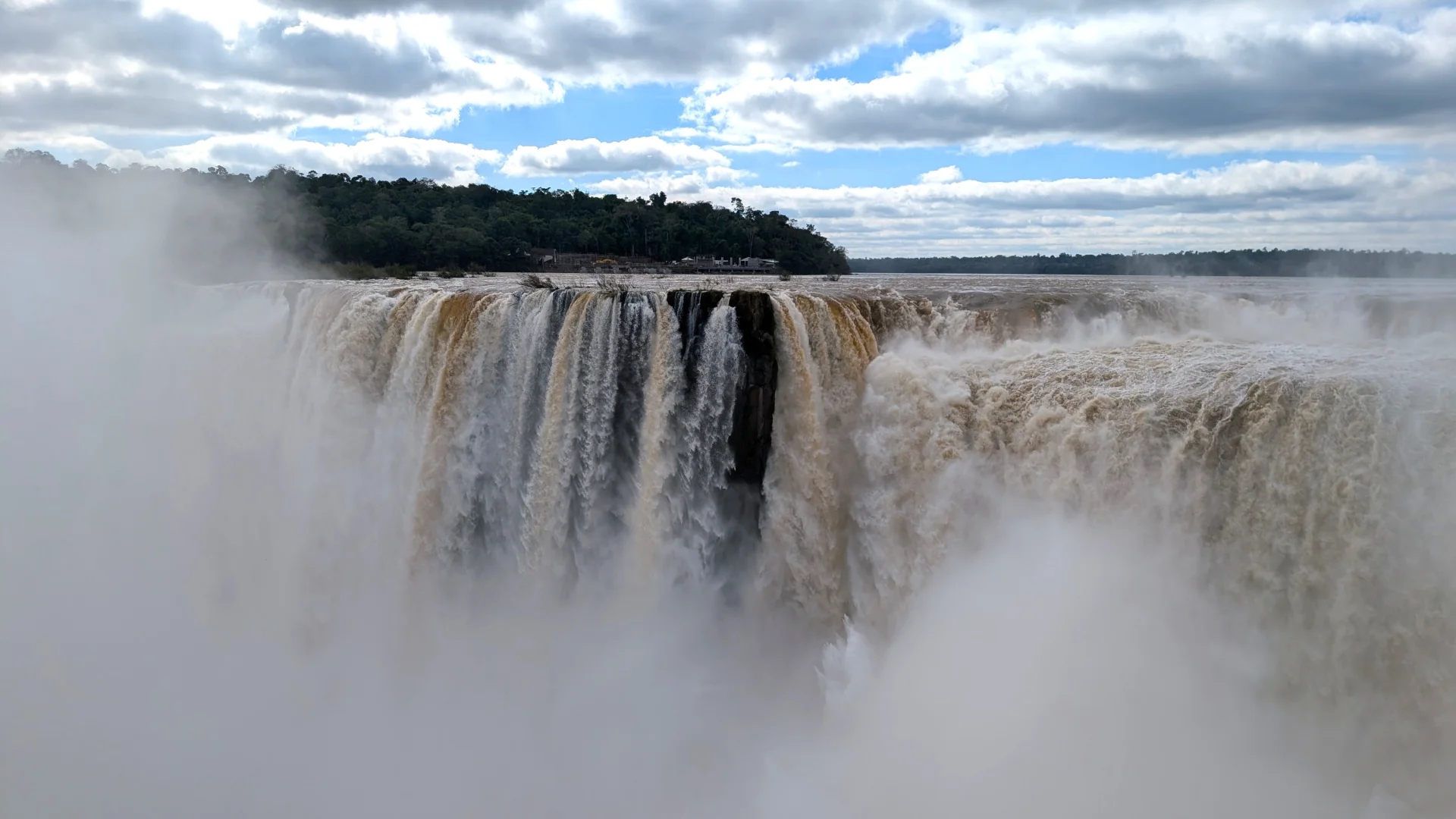 Vista de prop de la Garganta del Diablo a les Cascades de l'Iguaçú, on una enorme i majestuosa massa d'aigua es precipita al buit creant una gegantina cortina de boira blanca sota un cel ennuvolat.